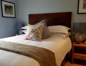 PensfordThe Carpenters Arms的一张带枕头的床和一张带棕色床头板的