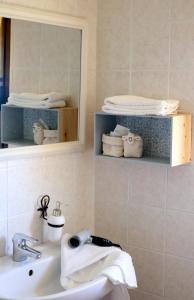 塞纳里奥罗La Rosa dei Venti的浴室配有盥洗盆、镜子和毛巾
