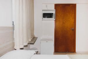 若昂佩索阿Flat Israel Unidade 308的一间设有一张床的房间和一扇带微波炉的门