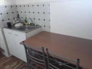 库里科Hostal Alessandri的厨房配有水槽和木桌