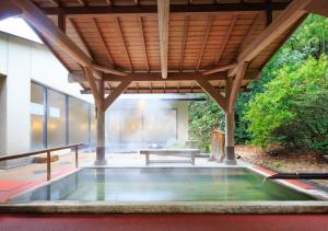 箱根汤本富士屋酒店的庭院中间的游泳池,带有木屋顶