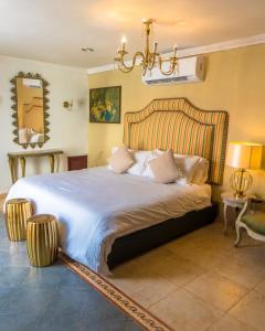 卡塔赫纳Hotel Casa la Tablada的一间卧室配有一张大床和一个吊灯。