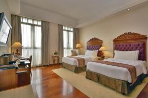 吉隆坡吉隆坡皇家朱兰酒店的大型酒店客房设有两张床和电视。