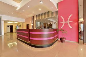 万隆Zodiak Kebon Kawung by KAGUM Hotels的粉红色墙壁的酒店大厅
