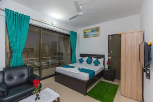 孟买Aristo Hospitality Services Apartment, 1402,14th Floor的一间卧室配有一张床、一张沙发和一把椅子