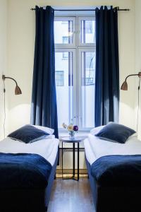 奥斯陆奥斯陆皇家公园奥卢弗雷蒙服务式公寓的配有蓝色窗帘和窗户的客房内的两张床