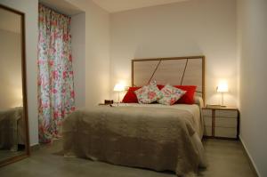 科尔多瓦ALHAJAS DE CORDOBA的一间卧室配有一张带红色枕头的大床