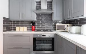 牛津The Oxford Loft - Central & Modern 2BDR Hidden Gem的厨房配有白色橱柜和炉灶烤箱。