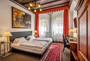 因戈尔施塔特Hotel Adler的一间卧室配有一张床、一张桌子和一张四柱床。