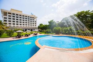 舍地Sun-n-Sand Suites, Shirdi的酒店前方设有带喷泉的游泳池