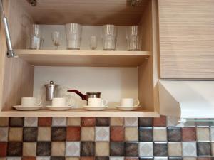 埃里温Lily's Apartment的橱柜,上面有杯子,碗碟,眼镜