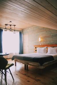 胡日尔Villa Malina Olkhon Baikal的一间卧室设有一张带木墙的大床