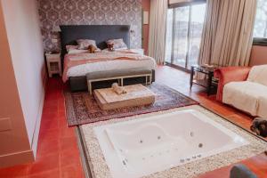 昆卡派纳精品酒店的卧室配有一张床和一个浴缸,位于地板上