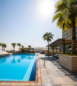 迪拜古赖尔瑞士生活酒店的一座棕榈树游泳池和一座建筑
