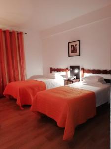 埃尔瓦斯布拉斯卡酒店的酒店客房带两张带橙色床单的床