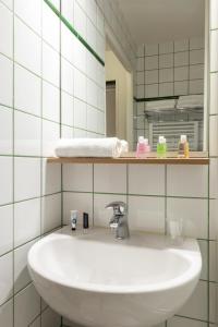 库尔布瓦拉德芳斯爱达格公寓式酒店 - 普莱斯查瑞斯的浴室设有白色水槽和镜子