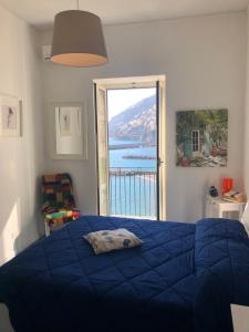 阿马尔菲Casa La Voce del Mare的一间卧室设有蓝色的床和大窗户