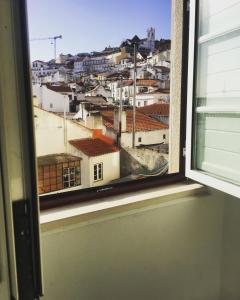 里斯本Pequeno Hostel Studio的从窗户可欣赏到城市美景