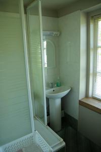 Ēdole卡佐基度假屋的浴室配有盥洗盆和带镜子的淋浴