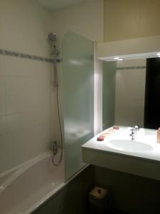 蒂涅瓦诺斯酒店的一间带水槽、浴缸和镜子的浴室