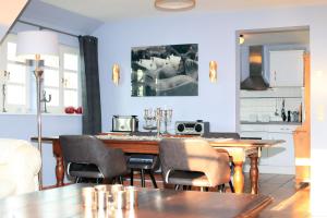 阿伦斯霍普Ferienwohnung im Blauen Haus的一间带木桌和椅子的用餐室