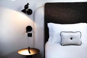 巴黎Hôtel Eiffel Saint Charles的卧室配有一张带白色枕头和桌子的床