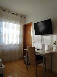 布尔格韦德尔Arkadia Hotel的客房设有书桌和墙上的电视。