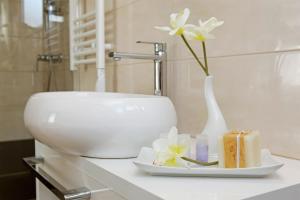 尼亚卢卡特林塔科尔丘拉旅馆的浴室水槽内有花卉白色花瓶