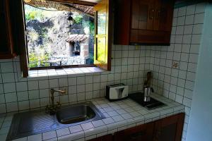 戈梅拉岛圣塞瓦斯蒂安CASA RURAL LOS FRONTONES的带水槽的厨房台面和窗户