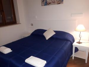 奇尼斯伊尔皮拉塔酒店的白色的房间里,有一张蓝色的床,有灯