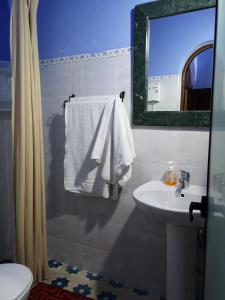 舍夫沙万库图比亚酒店的一间带水槽、卫生间和镜子的浴室