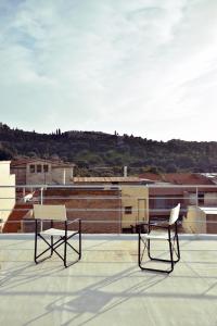 雅典Apartment with Rooftop Terrace & Acropolis View的两把椅子坐在屋顶上