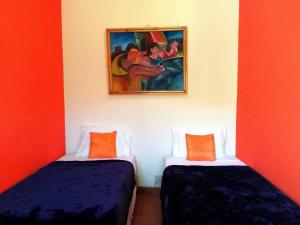 马塔加尔帕Hostal Casa Vieja的墙上画画的房间里设有两张床