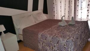 巴利亚多利德利马旅馆的一间卧室配有一张带两个天鹅的床