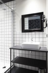 拉瓦勒Logis Hotel du Maine的白色的浴室设有水槽和镜子