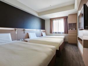 冈山冈山三井花园酒店 的酒店客房设有三张床和电视。