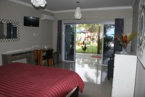 瑟克通银蕨海滩度假酒店的卧室配有红色的床和滑动玻璃门