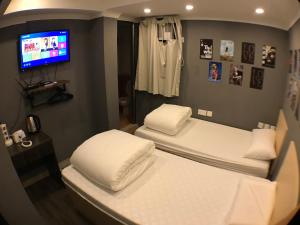 香港精品旅馆的配有电视的客房内的两张床