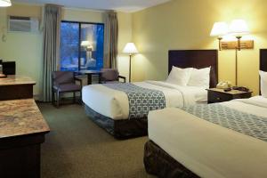 罗切斯特依可诺奇罗切斯特酒店的酒店客房配有两张床和一张桌子及椅子