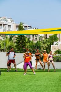 赫索尼索斯Grand Hotel Holiday Resort的一群人在草地上跳舞