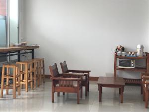 乌隆他尼UD Residence的客房设有木椅、桌子和微波炉。