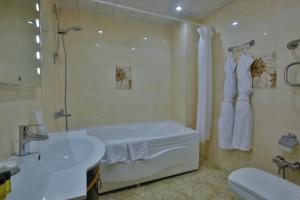 巴库甘雅丽广场酒店的带浴缸、盥洗盆和卫生间的浴室