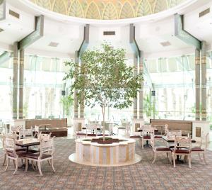 埃拉特Herods Palace Hotels & Spa Eilat a Premium collection by Fattal Hotels的大房间中间有桌子和一棵树