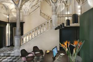 热那亚帕拉佐桂罗酒店的配有桌椅和笔记本电脑的房间
