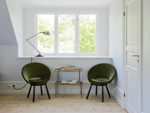 VästergarnHotel Stelor的窗户客房内的两张绿色椅子