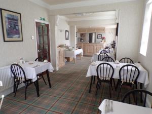 斯凯格内斯丽石酒店 的一间带白色桌椅的餐厅和一间厨房
