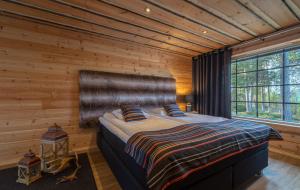 伊瓦洛Wilderness Hotel Nangu & Igloos的卧室配有木墙内的一张床