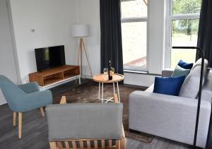 BirdaardWaterdorp Burdaard的带沙发、桌子和电视的客厅