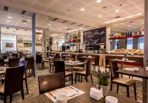 埃拉特埃斯特拉马里斯酒店的餐厅设有木桌、椅子和柜台
