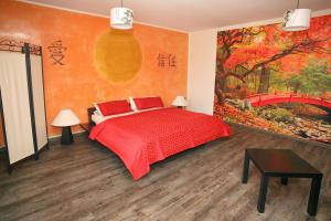 艾本施托克Kunsthof Eibenstock的一间卧室配有一张红色的床和一幅桥画